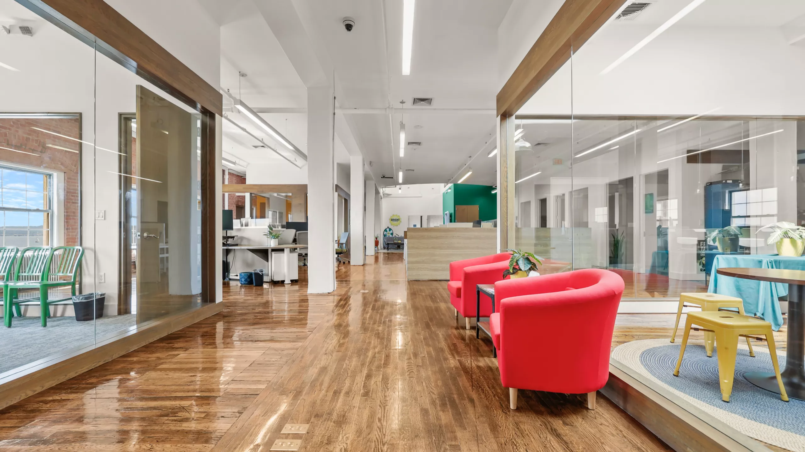 A sleek and airy office space with two plush red chairs as a focal point. The clean, modern design and abundance of natural light create a comfortable and inspiring setting.